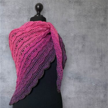 Pink to purple ombre crochet triangle shawl with scalloped edge on black dress form