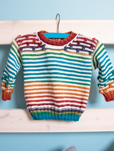 Gestrickter Baby-Pullover mit bunten Streifen und Bobbel-Verzierung am Bügel