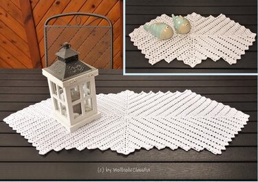 Weißer gehäkelter Tischläufer mit gezacktem Rand und Laterne auf dunklem Holztisch