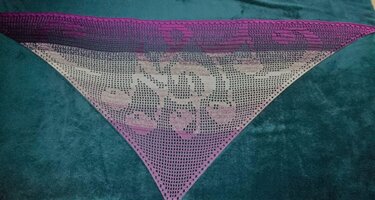 Gehäkeltes Dreieckstuch in Lila‑Rosa‑Beige mit Farbverlauf und floralem Filetmuster auf dunklem Untergrund