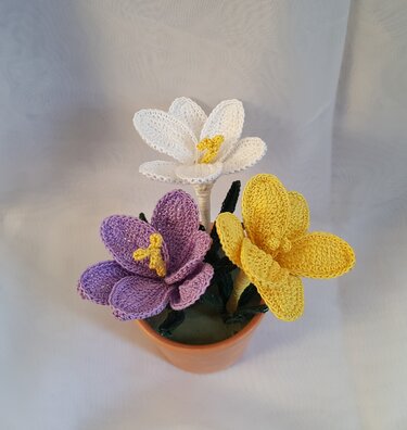 Gehäkelte krokusähnliche Blumen im Topf als Vorlage für ein Häkelprojekt