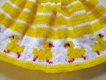 Gestricktes gelb-weiß gestreiftes Babyteil mit Entenbordüre am Saum