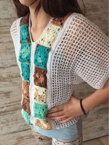 Weißes gehäkeltes Shirt mit luftigen Netzärmeln und vertikaler Reihe aus bunten Granny-Squares in Türkis, Braun und Creme.