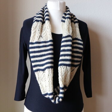 Gestrickter Loop-Schal in dunkelblau und creme mit Streifen und Ajourmuster auf einer Schaufensterpuppe