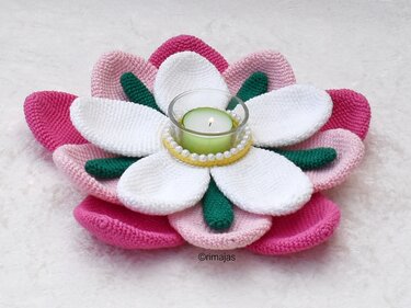 Gehäkelter Blumen-Teelichthalter in Rosa, Weiß und Grün mit brennender Kerze