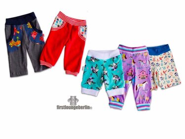 Fünf bunte Baby- und Kinderhosen mit elastischen Bündchen und verschiedenen Mustern, Hosen mit aufgesetzten Taschen, auf weißem Hintergrund