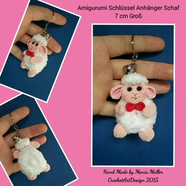 Gehäkelter Amigurumi-Schlüsselanhänger in Schafform mit roter Schleife und Glöckchen