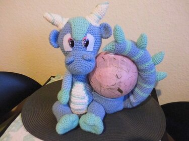 Gehäkeltes blau-mintgrünes Drachen-Amigurumi mit zartrosa Ei