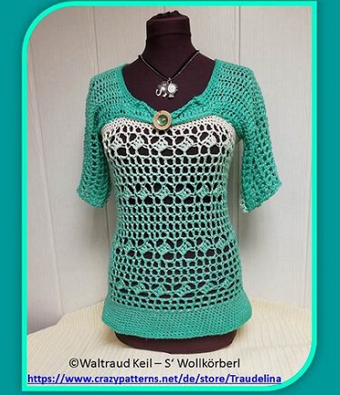 Türkis‑weißes gehäkeltes Damen‑Shirt mit Lochmuster, Dreiviertelärmeln und Zierknopf auf Mannequin