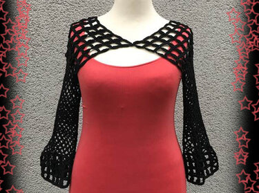 Schwarzer gehäkelter Bolero mit langen Ärmeln und offenem Netzmuster auf Schaufensterpuppe über rotem Top