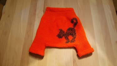 Orange gehäkelte Babyhose mit schwarzer Katzen-Silhouette