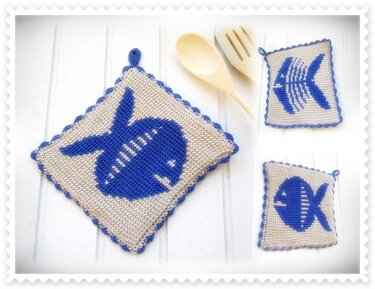 Drei gehäkelte Topflappen in Beige mit blauen Fischmotiven und blauem gezacktem Rand auf hellem Holzhintergrund.