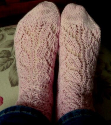 Detailaufnahme rosa gestrickter Socken mit sichtbar ausgearbeitetem Blatt-Ajourmuster