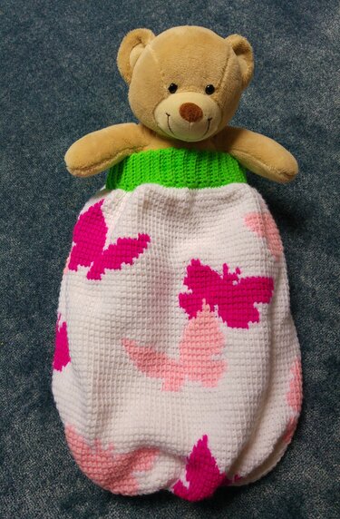 Weißer Babyschlafsack im Pixelhäkelmuster mit rosa und pinken Schmetterlingen und grünem Rippenbündchen