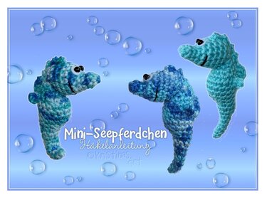 Drei gehäkelte Mini-Seepferdchen in Blau und Türkis vor hellblauem Hintergrund mit Blasen.