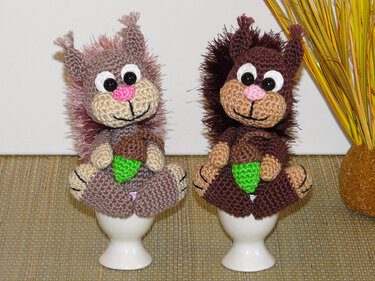 Zwei gehäkelte Eichhörnchen-Eierwärmer in Braun und Beige auf Eierbechern