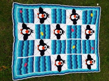 maritim gestaltete gehäkelte Babydecke mit Pinguinen und wellenförmigen Streifen