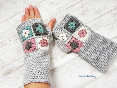 Hellgraue gehäkelte Armstulpen mit pastellfarbenen Granny-Squares, eine getragen, eine daneben