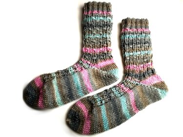 Paar handgestrickter Socken mit braunen, mint- und rosafarbenen Streifen und strukturiertem Schaft auf weißem Hintergrund