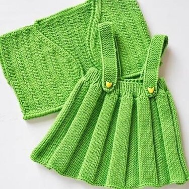 Grünes gestricktes Trägerkleid mit gelben Herzknöpfen und passende, strukturierte Decke