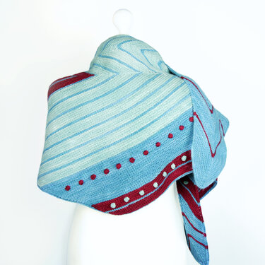 Pale blue and mint striped knitted shawl with red and white bobble details and a deep red border on a white background.