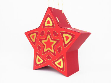 Weihnachtsstern aus rotem Papier mit gelben Mustern, aufgehängt