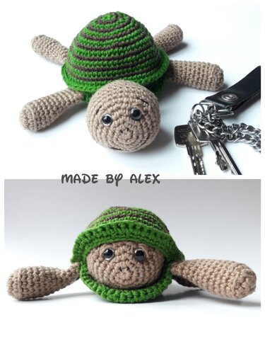 Gehäkelte Amigurumi‑Schildkröte mit grün-braun gestreifter Schale neben einem Schlüsselbund.
