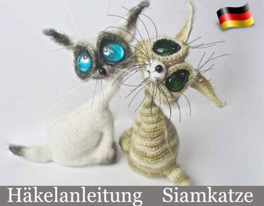 Zwei gehäkelte Amigurumi-Siamkatzen mit großen, glänzenden Augen und langen Schnurrhaaren; Schriftzug ‚Häkelanleitung Siamkatze‘ am Bildrand.