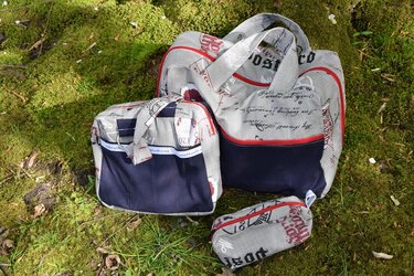 Dreiteiliges Taschen-Set mit Schriftzugmuster auf Moosboden