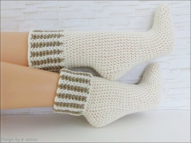 Gehäkelte cremeweiße Socken mit umgeschlagenem Streifenbündchen, an Beinen getragen