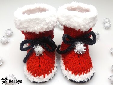 Rote gestrickte Babystiefel mit weißem Plüschrand und schwarzen Schleifen
