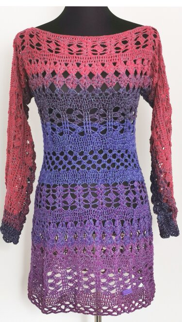 Gehäkelte Damen-Tunika mit Langärmeln und Ajourmustern, Farbverlauf von Rot über Blau zu Violett, auf schwarzer Mannequin