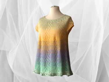 Pastellfarbene gestrickte Tunika auf Schneiderpuppe mit Struktur- und Lochmuster