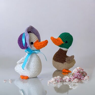 Zwei gehäkelte Amigurumi-Enten in Kontrastfarben mit sichtbarer Maschenstruktur