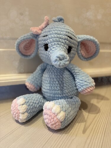Gehäkelter Amigurumi‑Elefant aus hellblauem Plüschgarn mit rosa Details und Schleife