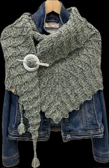 Meliertes Dreieckstuch mit Strukturmuster und Quasten stilvoll über einer Jeansjacke drapiert