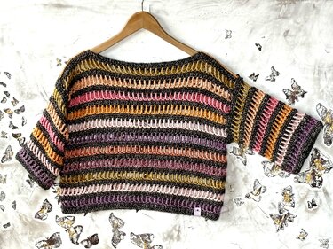 Gehäkeltes kurz geschnittenes Damen-Shirt mit bunten Querstreifen auf Holzbügel