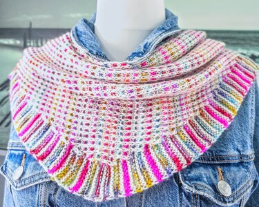 Gestricktes Dreieckstuch in Weiß mit bunten Sprenkeln und gestreiftem Rand auf einer Schaufensterpuppe