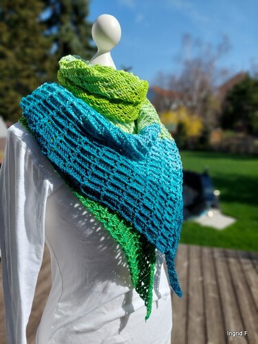 Gehäkeltes Dreieckstuch mit Farbverlauf in Blau- und Grüntönen auf Schaufensterpuppe