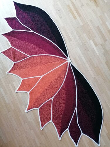 Gestricktes halbrundes Tuch in Blattform, Farbverlauf von Orange zu Dunkelviolett mit weißen Kanten