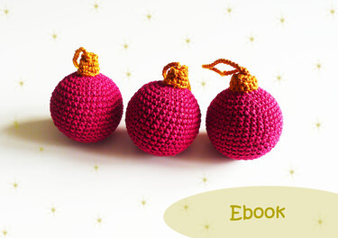 Three pink crocheted Christmas ornaments with golden-yellow hanging loops