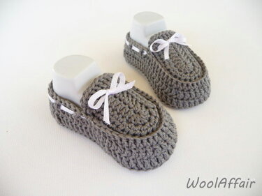Gehäkelte graue Babyschuhe mit weißem Band