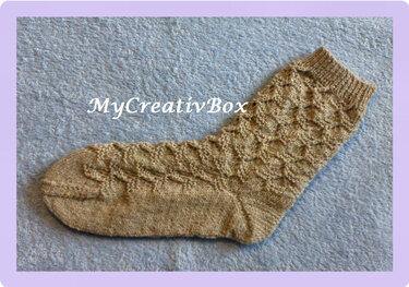 Einzelne beige gestrickte Socke mit Strukturmuster, geripptem Bündchen und glattem Fuß