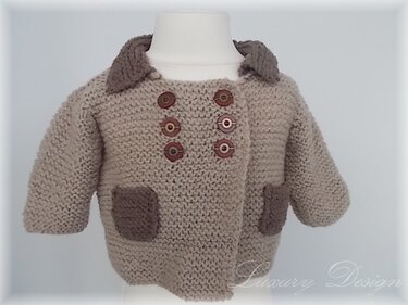 Beigefarbene gestrickte Kinderjacke mit zweireihiger Knopfleiste, aufgesetzten Taschen und kontrastierendem Kragen