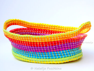 Ovaler gehäkelter Korb mit regenbogenfarbenen Streifen und umgeschlagenem Rand
