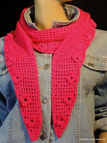 Gehäkelter pinker Dreiecksschal mit kleinen Blüten, über einer Jeansjacke drapiert