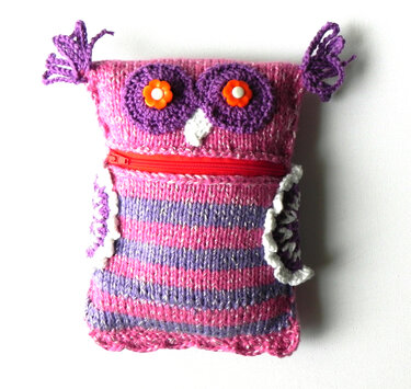 Gestrickter Eulenbeutel mit pink-lila Streifen, lila Augen und rotem Reißverschluss