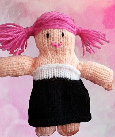 Gestrickte Amigurumi-Puppe mit leuchtend pinken Zöpfen und schwarzem Kleid