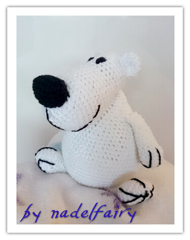 Weißer gehäkelter Amigurumi-Eisbär mit schwarzer Nase und Augen, sitzend