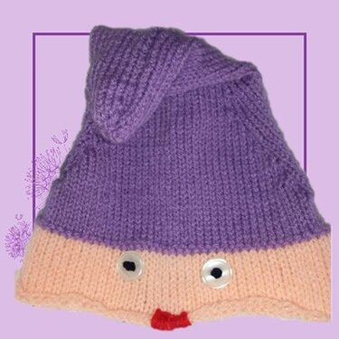 Gestrickte Kindermütze in Lila und Beige mit Knopfaugen und rotem Mund